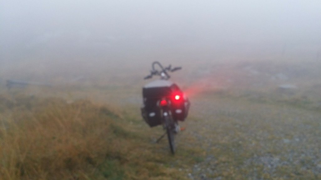 fiets in d mist boven op de Splügenpass