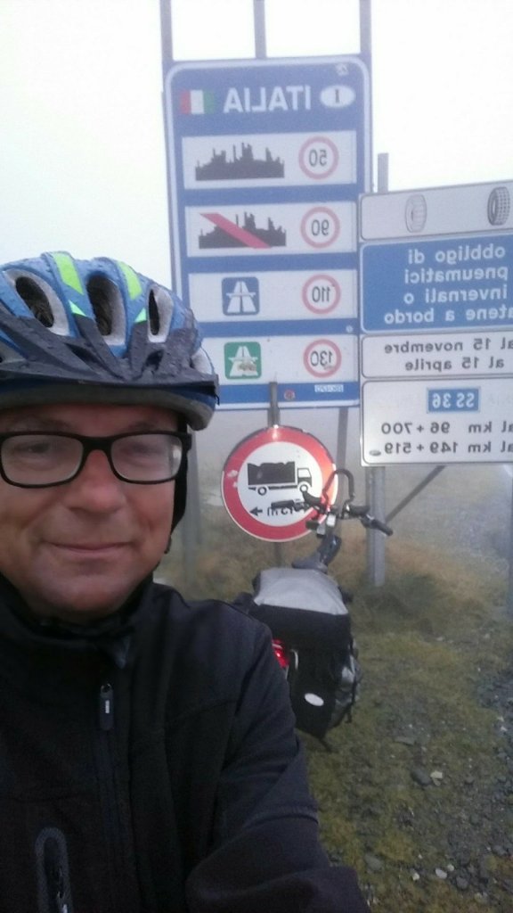 Fietser voor grensovergang boven op de Splügenpas Italië in
