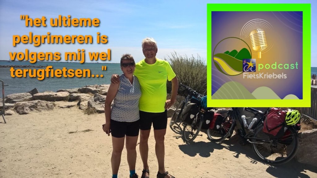 Twee fietsers staan op een strand met een zeeachtergrond, omringd door fietsen met bagage. Een tekstkader laat een citaat zien dat verwijst naar pelgrimeren en fietsen.