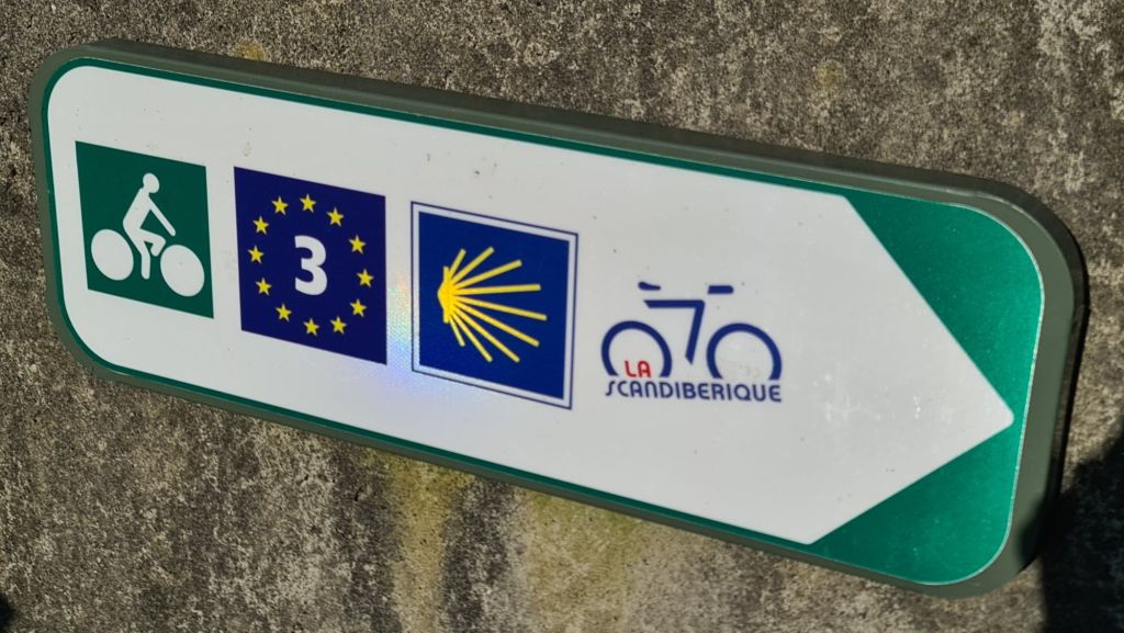 Wegwijzer voor fietsers met de symbolen voor EuroVelo 3, La Scandibérique en een fietser.