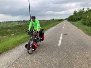 Fietser met gele jack op een asfalt weg