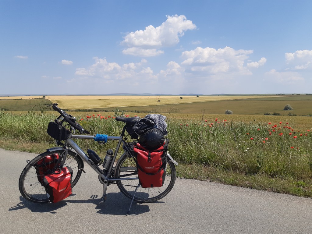 Dwars door de Donau fiets van jan Fossen op asfaltweg voor een groen landbouw gebied